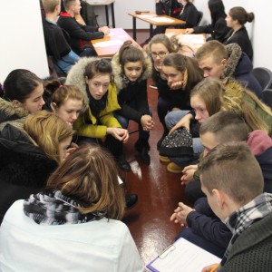 Grupėmis susėdę mokiniai diskutuoja.