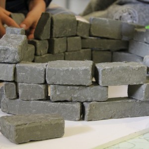 Moksleiviai stato statinį iš pilkos spalvos modelino gabalėlių, savo forma primenančių plytas, betono gabalus.